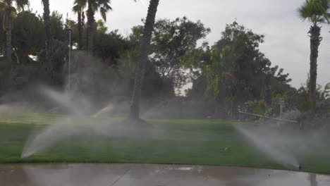 Slow-motion-of-working-irrigation-sprinklers-on-a-green-lawn