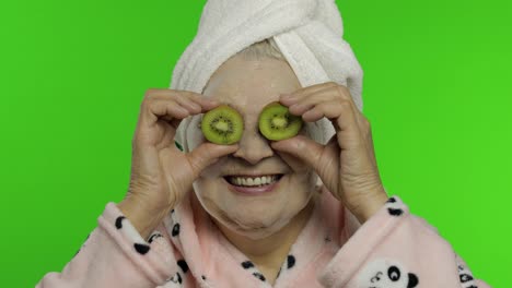 Elderly-grandmother-in-bathrobe-with-bubble-face-mask.-Old-woman-with-kiwi
