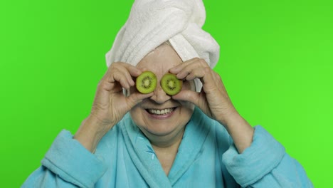 Elderly-grandmother-in-bathrobe-after-shower.-Old-woman-with-two-halves-of-kiwi