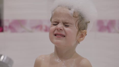 Attractive-three-years-old-girl-takes-a-bath.-Cute-blonde-child