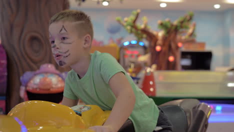 Child-is-attracted-with-racing-simulator-in-amusement-park
