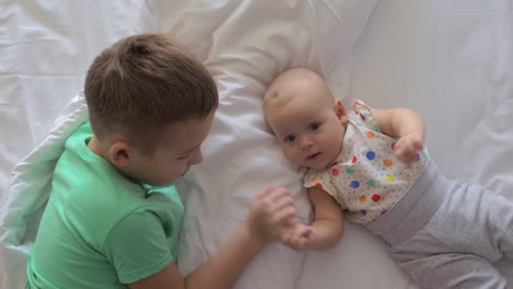 Boy-and-baby-girl-siblings-on-bed-at-home