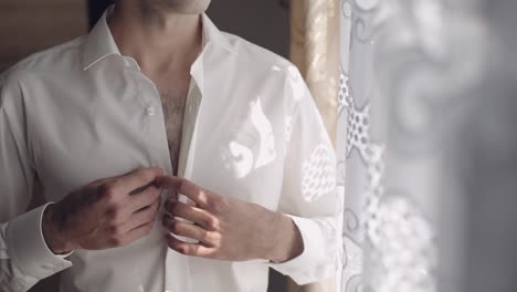 Handsome-groom-fixes-his-shirt.-Wedding-morning.-Slow-motion