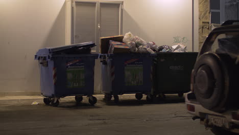 Full-garbage-containers-in-the-street-at-night