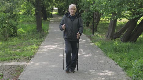 Anciano-Activo-Entrenando-Marcha-Nórdica-Con-Bastones-De-Esquí-En-El-Parque