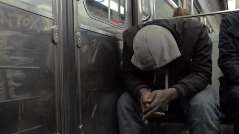 Homeless-man-in-shabby-clothes-traveling-by-subway-train