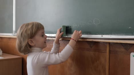 Mädchen-Zeichnet-Im-Klassenzimmer-Mit-Kreide-An-Die-Tafel.-Bildungsprozess