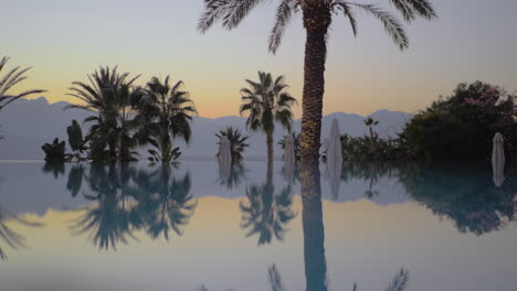 Evening-scene-on-resort-Swimming-pool-palms-and-mountains