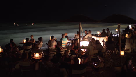 People-relaxing-in-outdoor-sea-shore-cafe-at-night