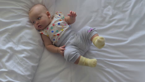 Active-baby-girl-on-bed-at-home