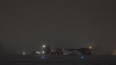 Snow-plough-cleaning-runway-in-airport-at-night