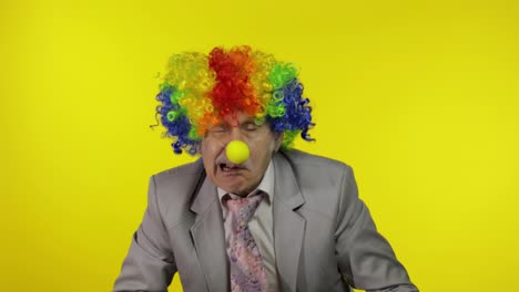 Elderly-clown-businessman-entrepreneur-boss-making-silly-faces.-Copy-space