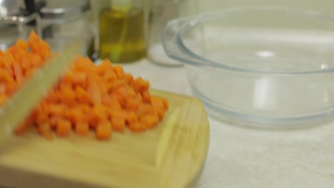 Female-housewife-hands-puts-pieces-of-sliced-carrot-into-salad-plate
