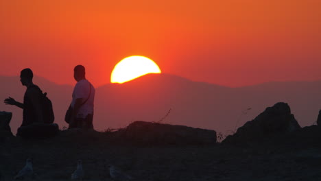 Männer-Gehen-Vor-Sonnenuntergang-Und-Berghintergrund