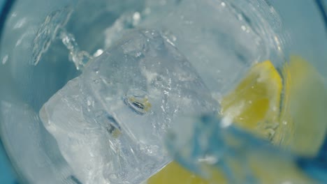 Frisches-Wasser,-Das-Mit-Eis-Und-Zitrone-In-Ein-Hohes-Glas-Gegossen-Wird
