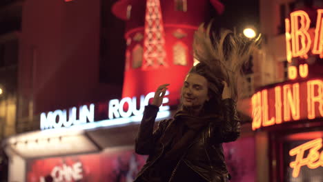 Mujer-Turista-Posando-Para-Hacer-La-Mejor-Foto-Cerca-Del-Moulin-Rouge-En-La-Noche-De-París