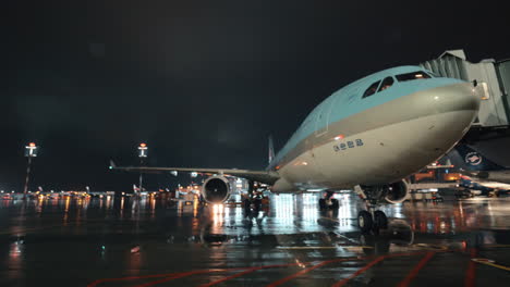 Passenger-airplane-of-Korean-Air-with-boarding-bridge-night-view