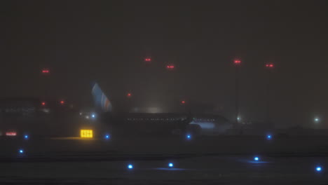 Flydubai-airplane-on-runway-at-night-airport-in-winter