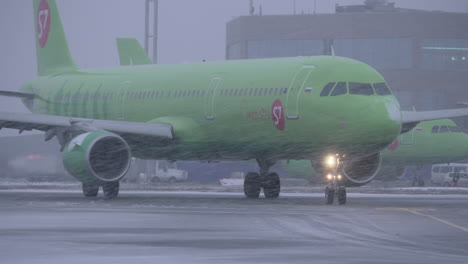 Flugzeug-Der-Fluggesellschaft-S7,-Das-Auf-Der-Landebahn-Des-Flughafens-Domodedowo-Fährt,-Blick-Auf-Den-Schneefall
