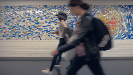 People-walking-in-pedestrian-underpass-mosaic-on-walls-Paris-France