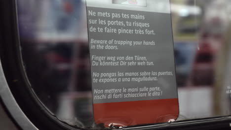 Warning-sticker-in-moving-metro-train-Paris