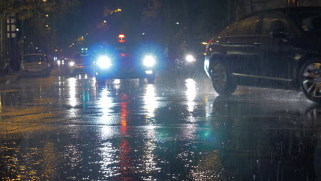 Cars-with-bright-headlights-beam-driving-in-city-at-rainy-night-Paris-France