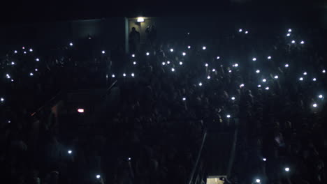 People-with-lights-at-the-concert-in-dark-music-hall