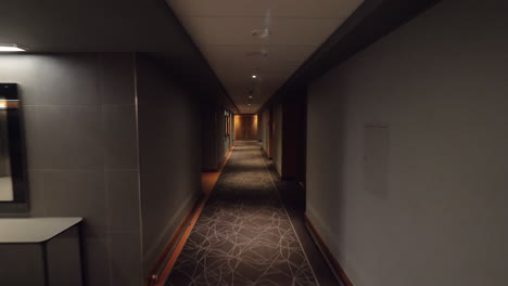 Walking-to-the-room-through-empty-hallway-in-hotel
