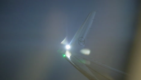 Blick-Durch-Die-Beleuchtung-Auf-Den-Flugzeugflügel-Mit-Blinkenden-Lichtern