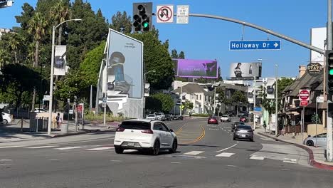 Cars-Passing-Intersection-On-Busy-Sunset-Boulevard,-First-Person-View