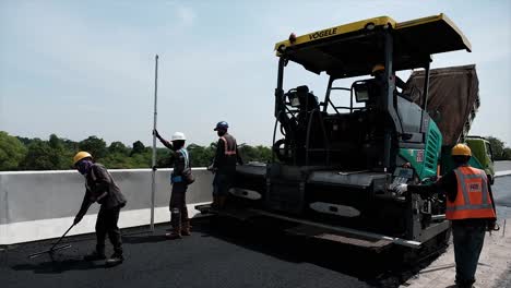 Compressing,-compacting,-leveling-and-smoothing-the-asphalt-road-surface-using-a-Asphalt-Paver-Finisher