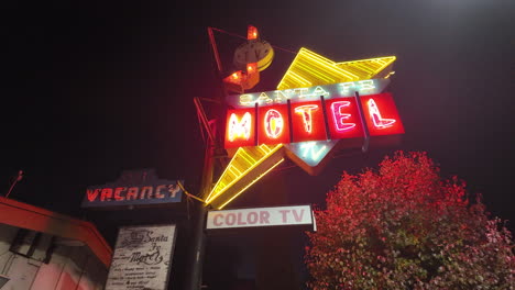 Bright-nostalgic-neon-sign-for-the-Santa-Fe-Motel-in-Tehachapi,-California-at-nighttime