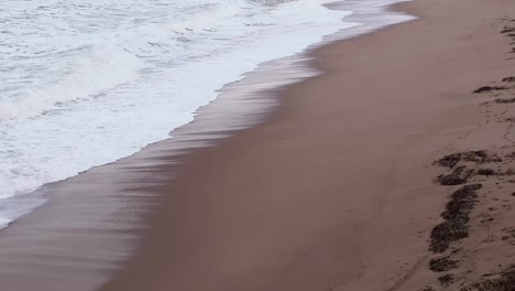 Aufnahmen-Von-Meereswellen,-Die-In-Einen-Majestätischen-Sandstrand-An-Der-Küste-Plätschern
