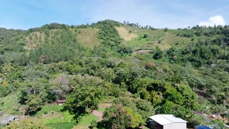 Drone-flying-over-farm-on-green-mountains-of-Bonao,-Dominican-Republic