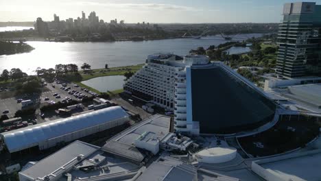 Aerial-approaching-shot-of-Luxury-Crown-Casino-Hotel-with-Swan-River-ans-Skyline-of-Perth-City-in-background---Sunset-time-in-Western-Australia
