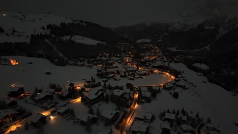 Aerial-top-down-shot-of-famous-tourist-town-in-Switzerland-named-Arosa-lighting-at-night-during-winter-season