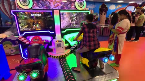 POV-SHOT-A-child-playing-a-game-with-a-bike-in-the-game-zone-inside-the-mall