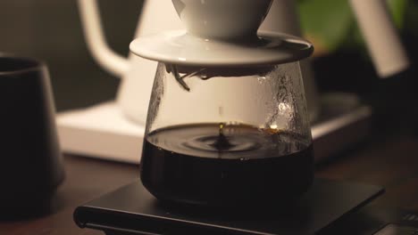 Fresh-brew-of-black-coffee-drip-into-glass-carafe-through-ceramic-dripper