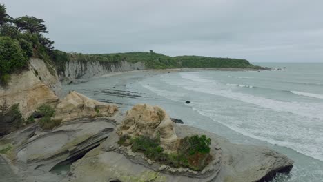 Aerial-drone-flight-over-raw,-wild-and-rugged-coastal-landscape-of-Omau-Cliffs-in-Cape-Foulwind-on-the-West-Coast-in-South-Island,-New-Zealand-Aotearoa