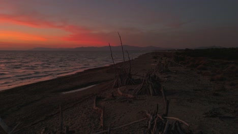 Holztipis-Am-Sandstrand-Bei-Sonnenuntergang