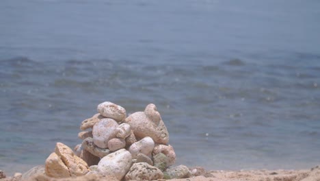 Focused-pile-of-coral-rocks-with-blurred-sea-waves
