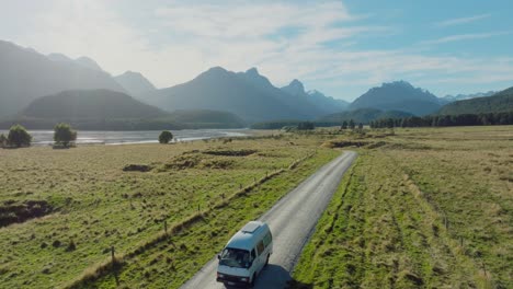 Aerial-view-of-tourist-campervan-on-road-trip-through-remote-rural-countryside-and-mountainous-landscape-in-Glenorchy,-South-Island-of-New-Zealand-Aotearoa