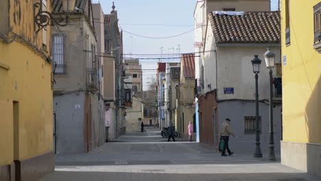 Street-with-old-houses-and-few-people-in-Valencia-Spain