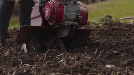 Person-using-motor-plow-for-small-land-plot,-close-up