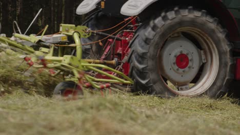 Tracking-shot-of-tractor-tires-passing-through-terrain-while-mowing-grass