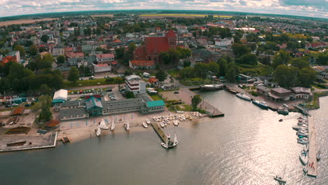 Aerial-shot-of-drone-flying-above-blue-baltic-sea-towards-the-Puck-city-in-Poland
