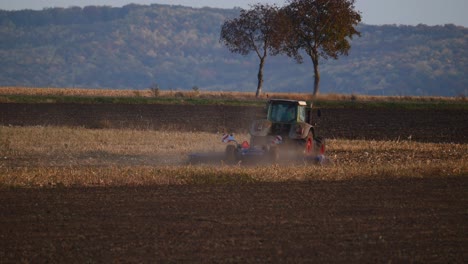 Dust-From-Farm-Tractor-Plowing-Field-In-Autumn