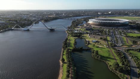 Aerial-wide-shot-showing-Swan-River,-Optus-Stadium-and-Matagarup-Bridge-in-Perth-City-during-golden-hour