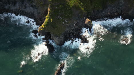 Waves-breaking-on-the-rugged-coastline-of-South-Cornwall,-England-seen-from-a-drone-point-of-view