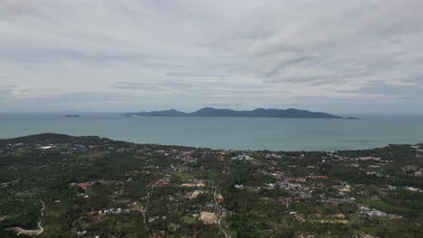 Volando-Sobre-La-Ciudad-Isleña-De-Koh-Samui,-Tailandia,-Capturando-Las-Hermosas-Colinas-Verdes-Y-Las-Aguas-Cristalinas-Del-Mar